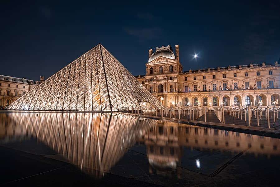 Which French landmark is adorned by a glass pyramid?